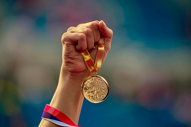 hand-woman-raising-olympic-gold-medal-victory_123827-29577